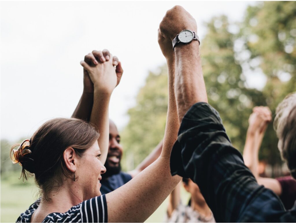 A group of people is holding hands up in the air